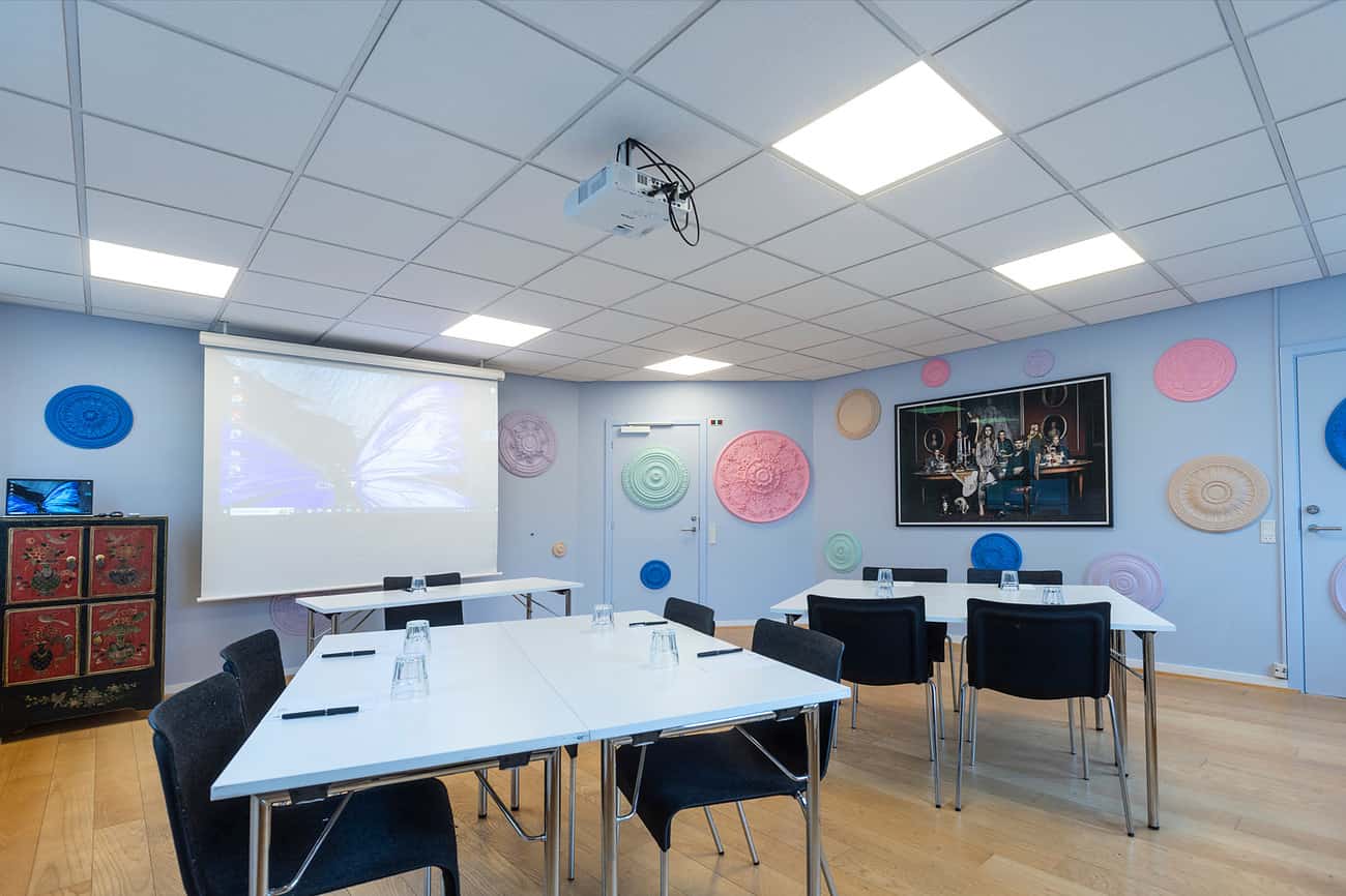 Mødelokale med farverige vægdekorationer og projektor