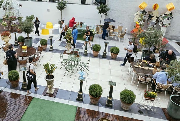 Udsigt over et udendørs mødeområde med borde og planter