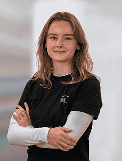 Ung kvinde med lyst hår står med armene over kors